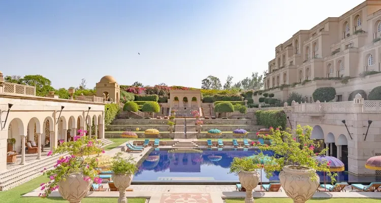 Oberoi Luxury Rajasthan Tour Package, showcasing a lavish resort poolside with elegant arches and vibrant parasols