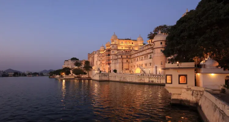 Udaipur City Palace at dusk by lake, highlighting beauty on Rajasthan Colorful Tour 8 Days.
