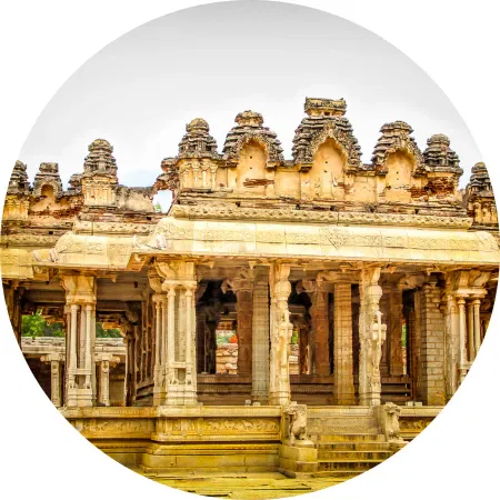 Sunset-lit Hampi temple ruins surrounded by boulders, ideal destination for a luxury India travel