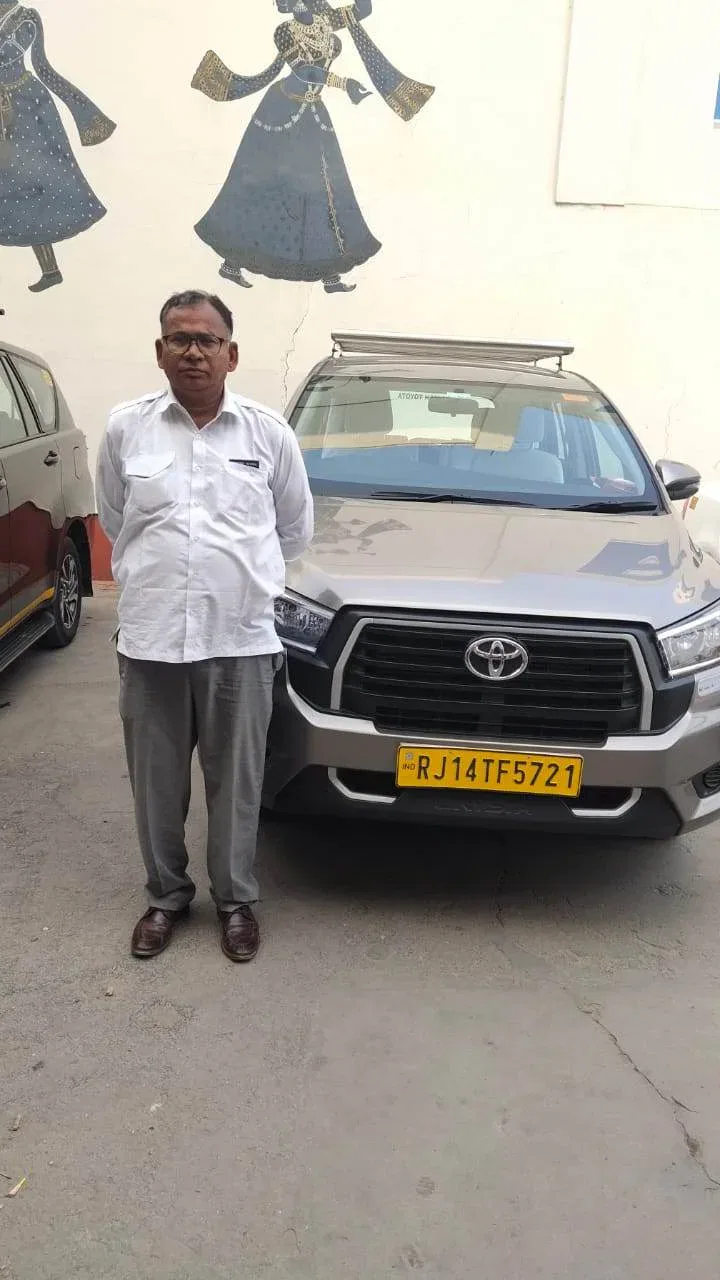 a man standing next to a Toyota sedan