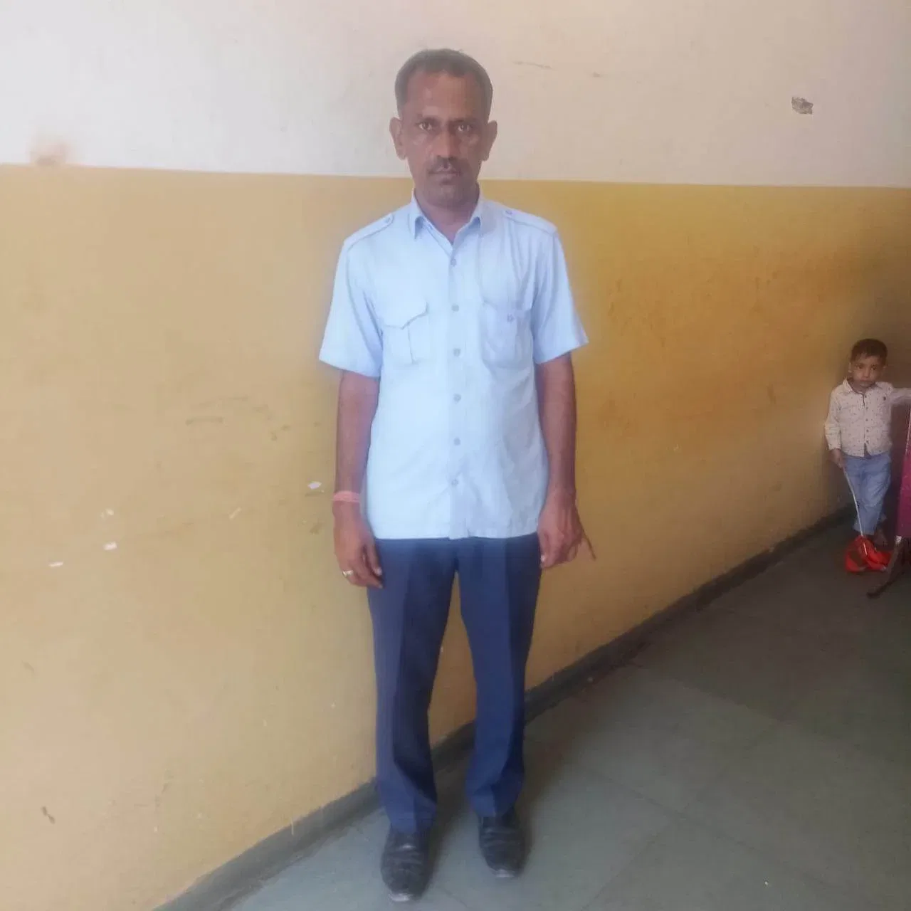 a person standing in front of a yellow wall