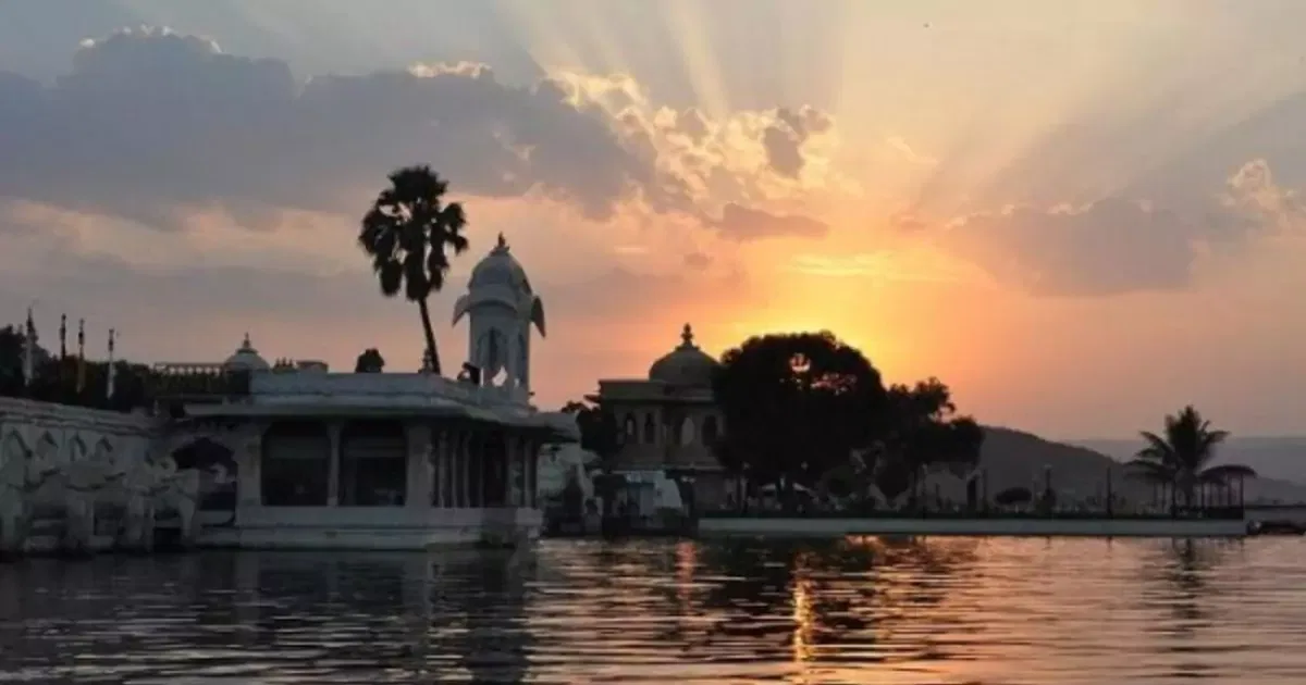 Udaipur lake with palace at sunset, reflecting on water 